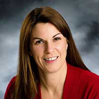 Headshot of a dark haired woman smiling
