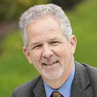 Headshot of a grey haired businessman smiling