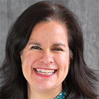 Headshot of a dark-haired businesswoman smiling