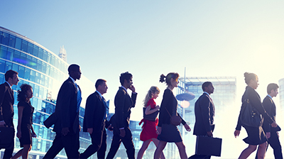 A large group of young business people crossing the street in a city