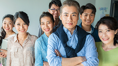 A group of seven people looking at the viewer while smiling 