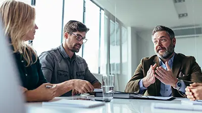 Colleagues dressed in casual attire conducting a meeting.