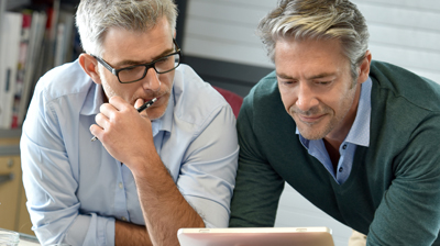 Two businessmen using a tablet