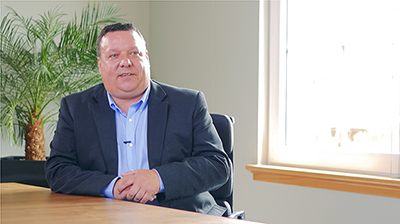 A man in an office with a small palm tree