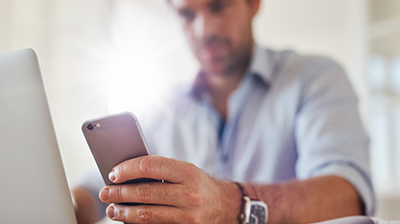 A man looking at his smart phone in his office