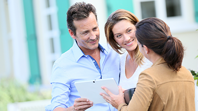 A man and two women looking at a tablet