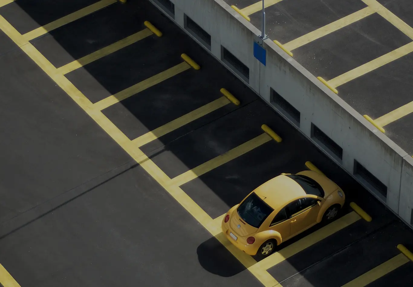 A Volkswagen Beetle is parked in a space