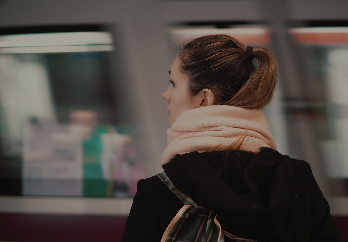 A woman is standing and looking while a train passes by