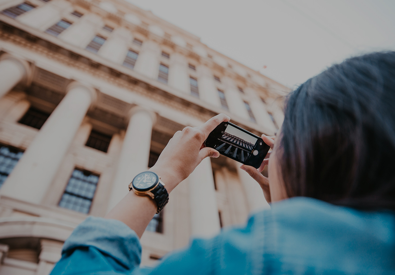 A person is looking up and taking a photo of a columns going up.