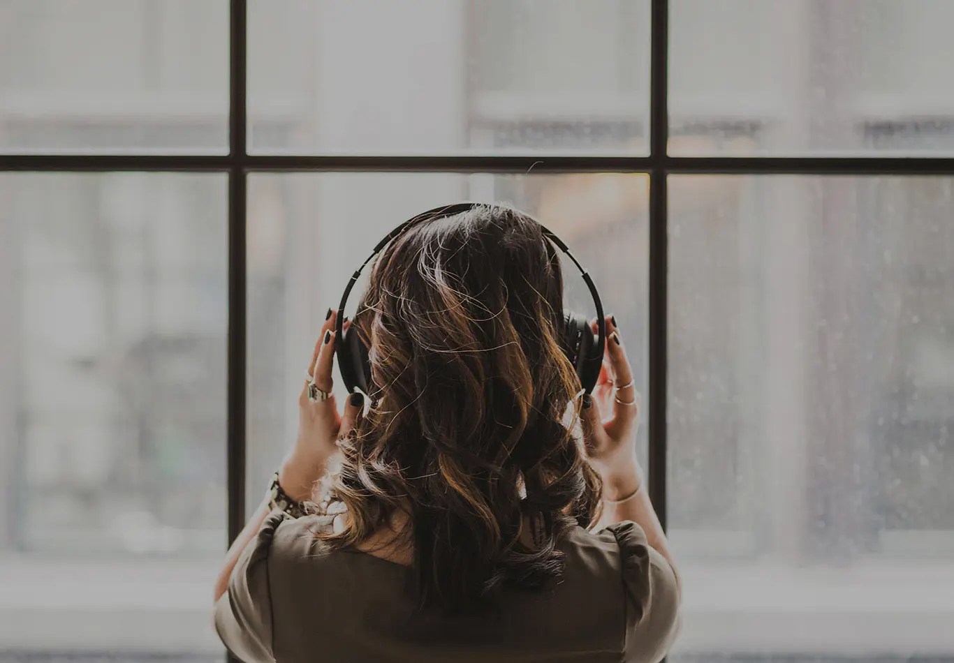 A person with long hair has headphones on their head
