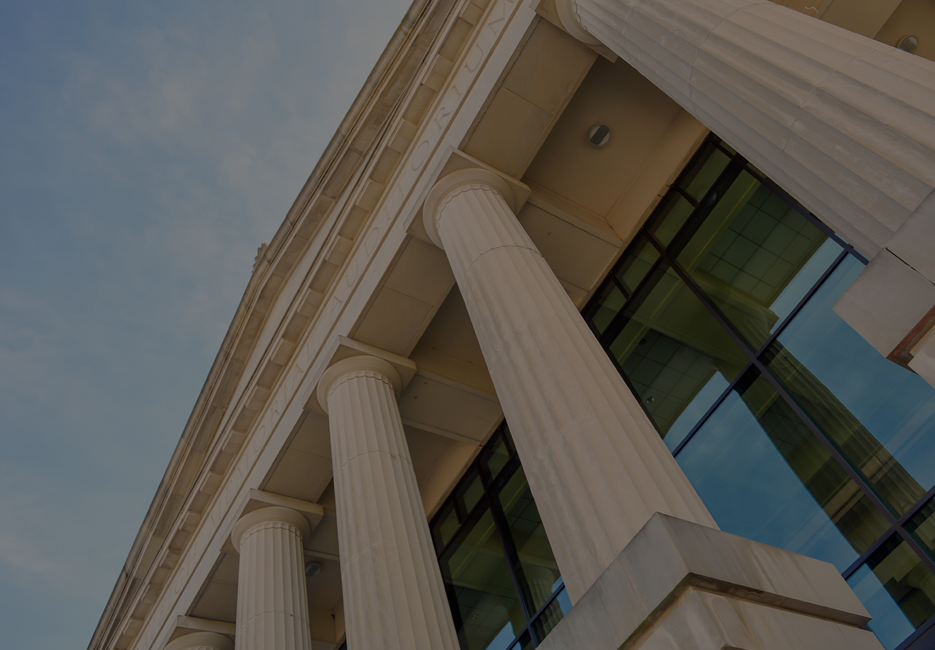 An upward shot of some roman style columns on a building 