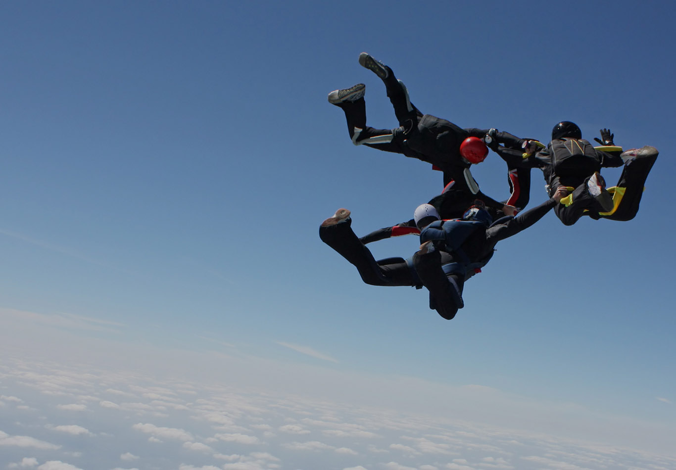 A group of people are skydiving in the clouds