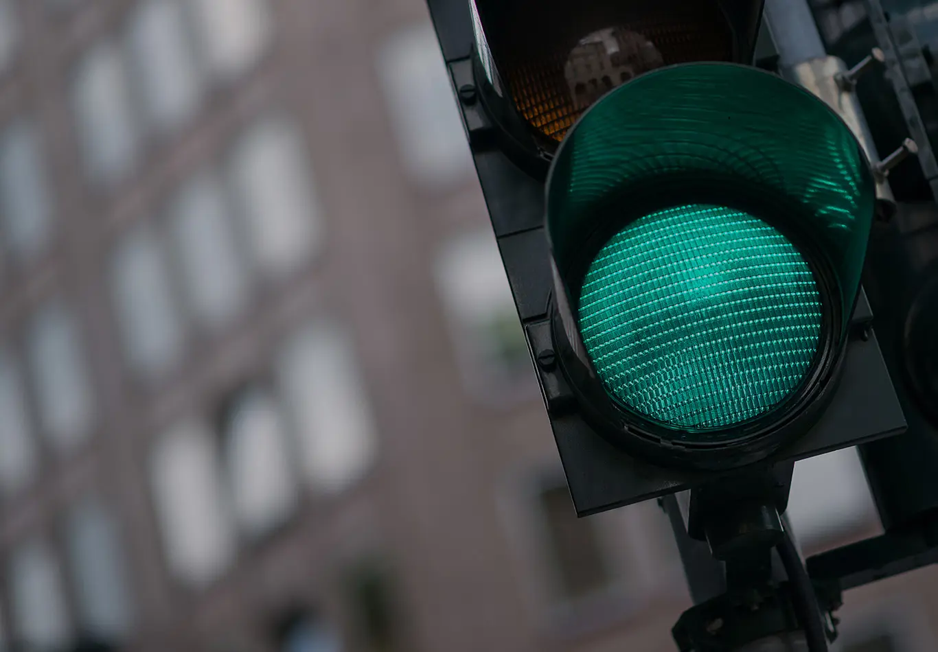 A close up of a green light on a stop light. The green light is on. 