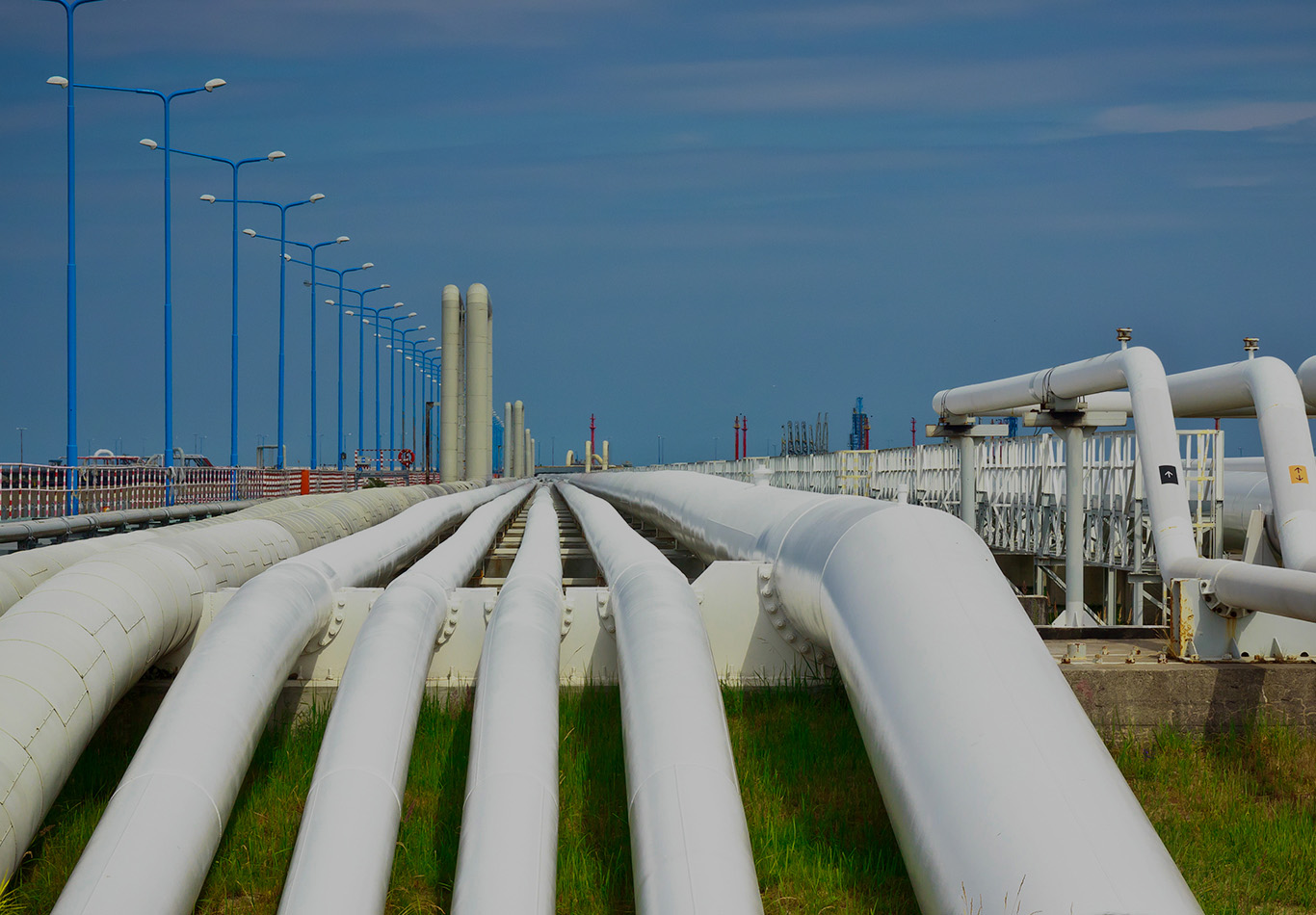 Pipes at a plant are heading off into the background