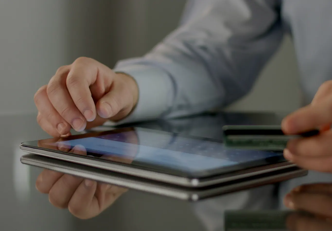 A person is reading a tablet that is sitting on a table