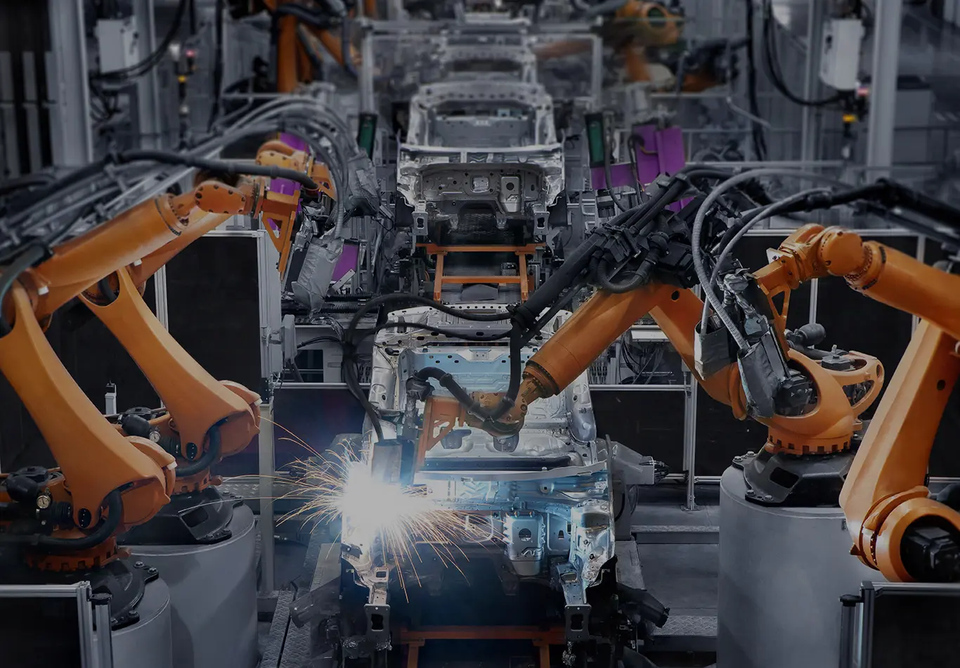 Robot arms on an assembly line welding an automobile
