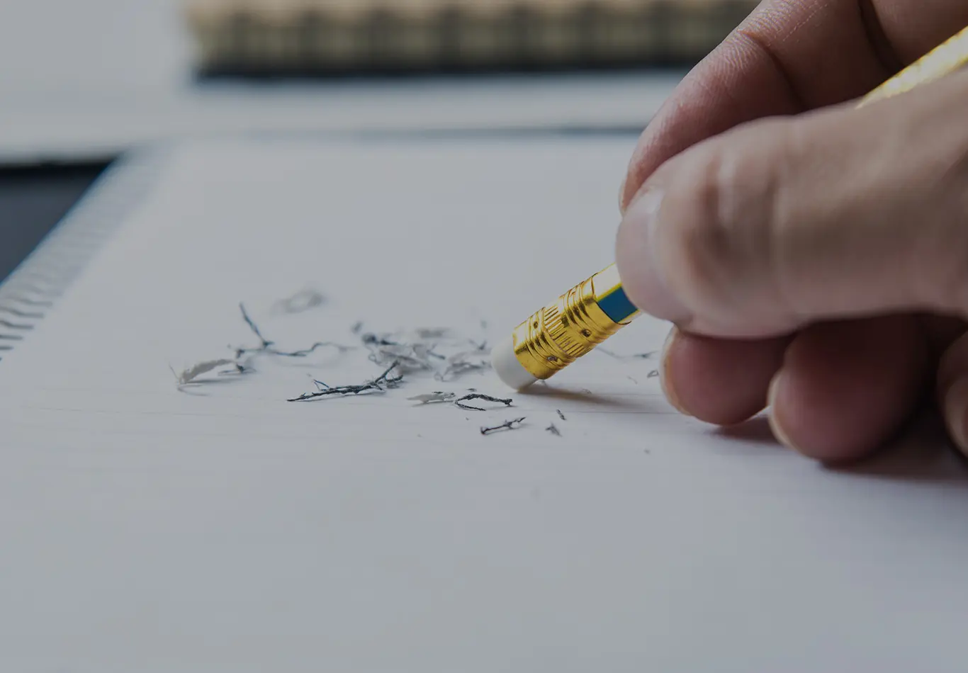 A hand holding a pencil is doing some erasing. 