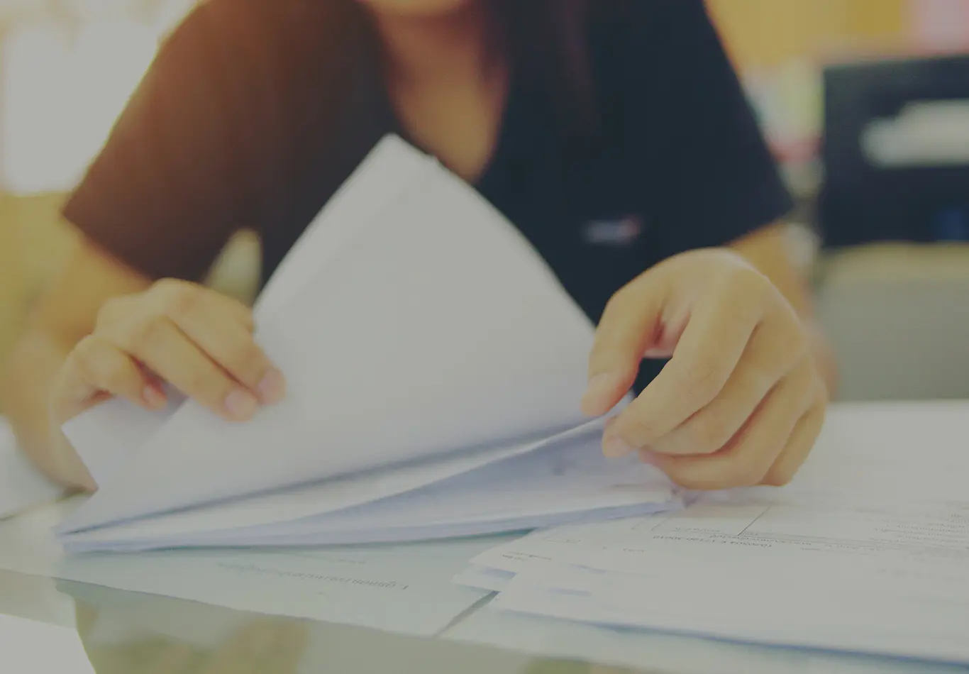 A person is flipping through some papers 