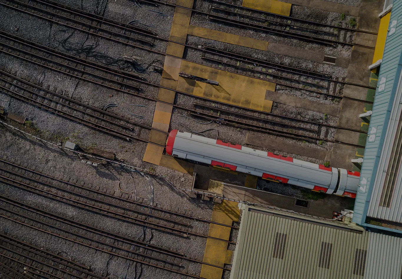 An aerial view of a train depot with one train on the train tracks