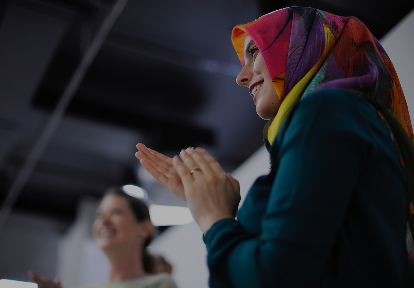 A woman in focus clapping her hands. 